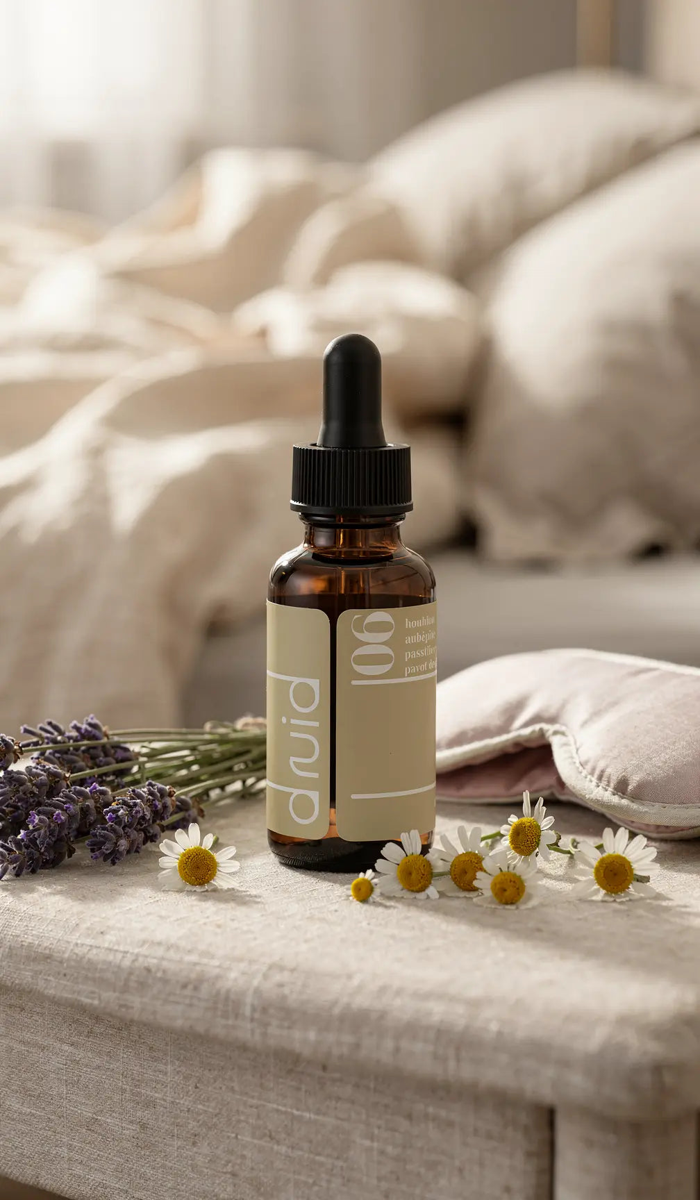 PET bottle with dropper on linen surface, label "Potion 06" beige tones, surrounded by lavender and chamomile flowers in bedroom setting.
