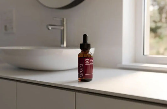 Flacon compte-gouttes pour soulager le syndrome prémenstruel sur une étagère de salle de bain
